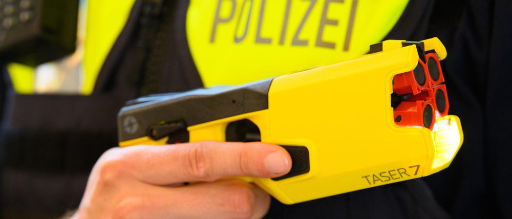 Ein Polizeibeamter hält im Rahmen der Pressekonferenz des Polizeipräsidenten im Jahr 2021 einen Taser in der Hand.