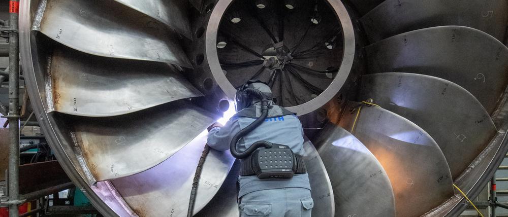 Ein Arbeiter eines Maschinen- und Anlagenbauers arbeitet an einer Wasserturbine.