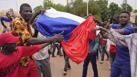 Anhänger meuternder Soldaten nehmen an einer Demonstration teil während sie eine russische Flagge halten.
