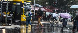 menschen mit regenschirm bei unwetter auf der straße menschen mit regenschirm bei unwetter auf der straße *** people with umbrella in storm on the street people with umbrella in storm on the street