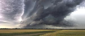 Wetterbild aus Haar Salmdorf /Landkreis Muenchen. Eine Gewitterfront bewegt sich bereits am fruehen Morgen in Richtung Sueden zu den Alpen-der Himmel ist dramatisch dunkel ueber einem Getreidefeld ?