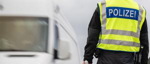 27.07.2023, Brandenburg, Frankfurt (Oder): Ein Transporter passiert einen Polizisten mit Haltekelle in der Hand. An deutschen Grenzen wurden im ersten Halbjahr 2023 mehr unerlaubte Einreisen von der Bundespolizei registriert als im Jahr zuvor. 