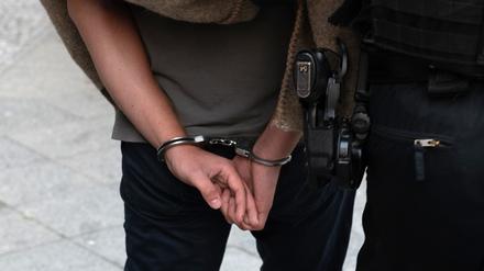 Polizisten führen einen verdächtigen Mann ab.