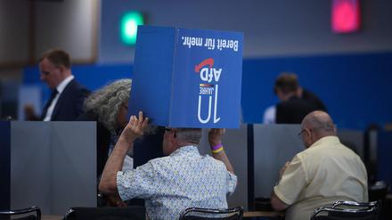 Delegates chat under a foldable ballot box during the European Election Assembly of German far-right party Alternative for Germany (AfD - Alternative fuer Deutschland) at the fair grounds in Magdeburg, eastern Germany on August 5, 2023. (Photo by Ronny HARTMANN / AFP)