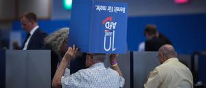 Delegates chat under a foldable ballot box during the European Election Assembly of German far-right party Alternative for Germany (AfD - Alternative fuer Deutschland) at the fair grounds in Magdeburg, eastern Germany on August 5, 2023. (Photo by Ronny HARTMANN / AFP)