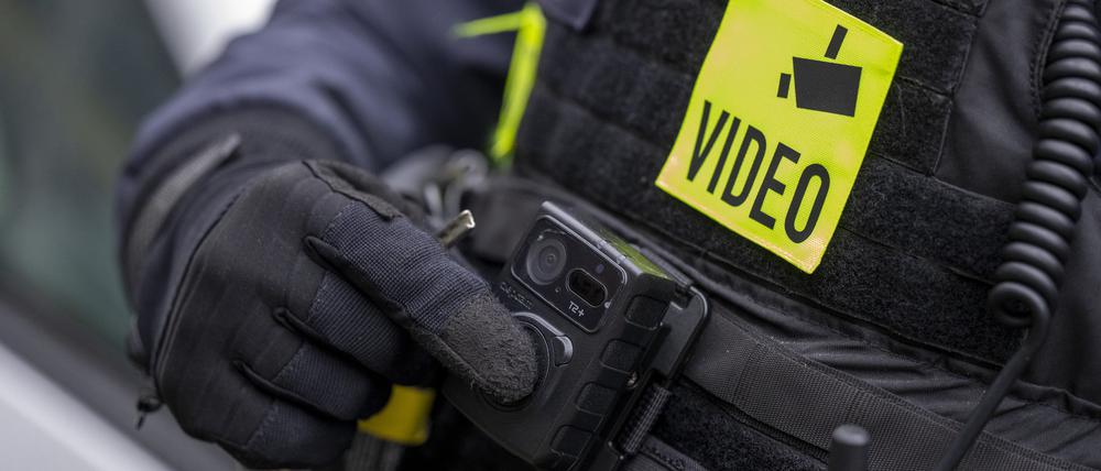 Ein Polizist schaltet die Bodycam auf seiner Uniform ein, aufgenommen bei einem Pressetermin zur Ausweitung des Einsatzes von Bodycams bei Berliner Polizei und Feuerwehr.