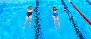 25.07.2023, Niedersachsen, Emden: Zwei Badegäst genießen das morgige Schwimmen im Freibad. Das van-Ameren-Bad hat am Dienstag um 6:00 Uhr wieder seine Pforten geöffnet, allerdings für den Rest der Saison im Notbetrieb. Foto: Lars Penning/dpa +++ dpa-Bildfunk +++