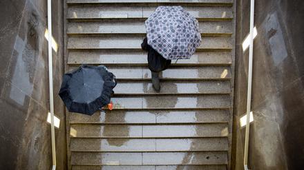 Passanten gehen am 09.09.2013 im Regen auf einer Treppe zum Potsdamer Platz in Berlin herauf. (Symbolbild)