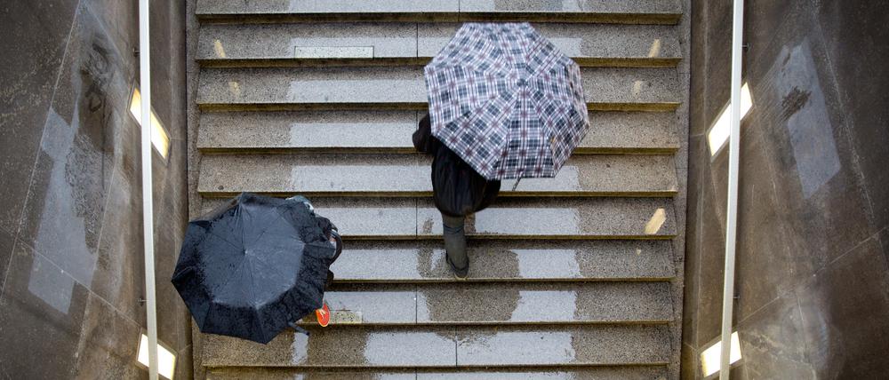 Passanten gehen am 09.09.2013 im Regen auf einer Treppe zum Potsdamer Platz in Berlin herauf. (Symbolbild)