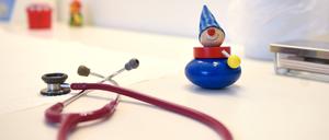 Ein Stethoskop und Kinderspielzeug liegen in einer Kinderarztpraxis auf einem Tisch.