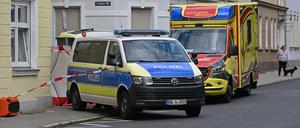 Einsatzfahrzeuge der Polizei und vom Rettungsdienst stehen am Tatort an der Trianonstraße.