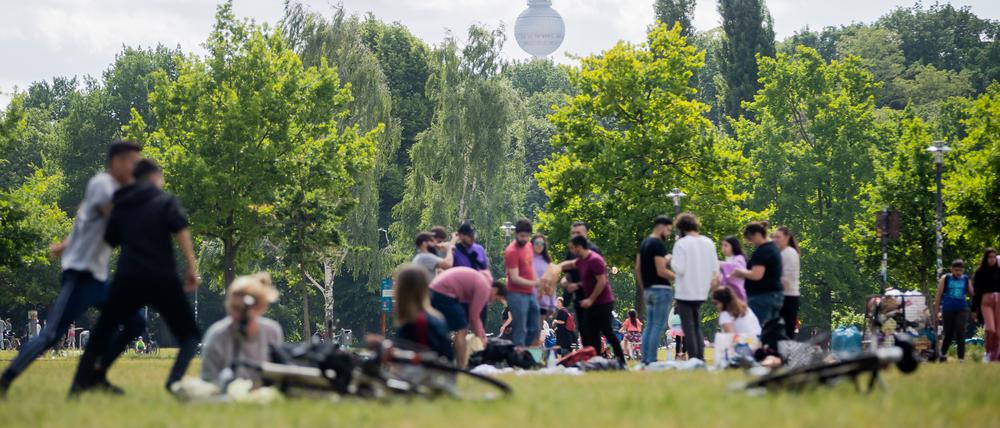 Menschen grillen und genießen das warme Wetter im Volkspark Friedrichshain.
