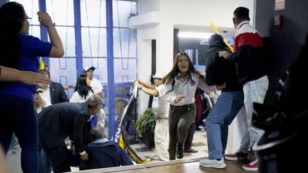 Menschen gehen in Deckung, nachdem am Ende einer Kundgebung des ecuadorianischen Präsidentschaftskandidaten Fernando Villavicencio in Quito am 9. August 2023 Schüsse abgefeuert wurden. 
