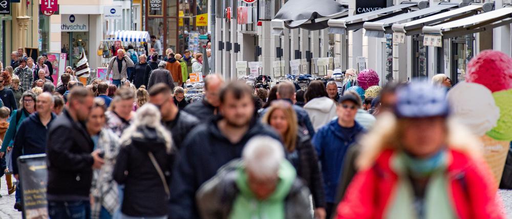 Passanten in einer Einkaufsstraße und Fußgängerzone.