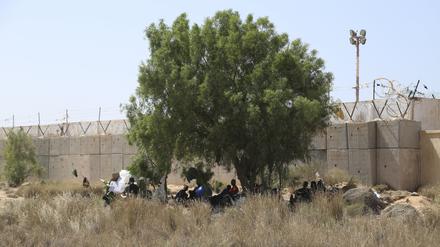 Migranten versammeln sich in einem Wüstengebiet auf der libyschen Seite der tunesisch-libyschen Grenze. 