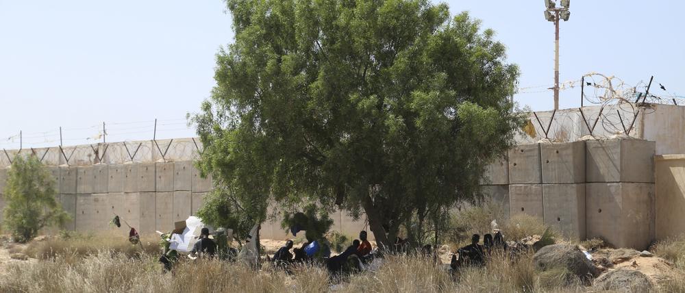 Migranten versammeln sich in einem Wüstengebiet auf der libyschen Seite der tunesisch-libyschen Grenze. 