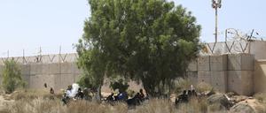 Migranten versammeln sich in einem Wüstengebiet auf der libyschen Seite der tunesisch-libyschen Grenze. 