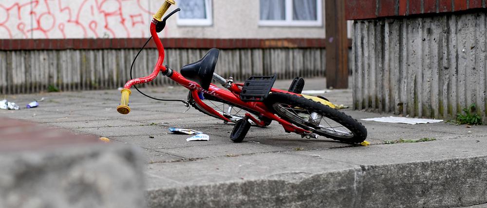 Ein Kinderfahrrad liegt in einem Aufgang zu einem Plattenbau.