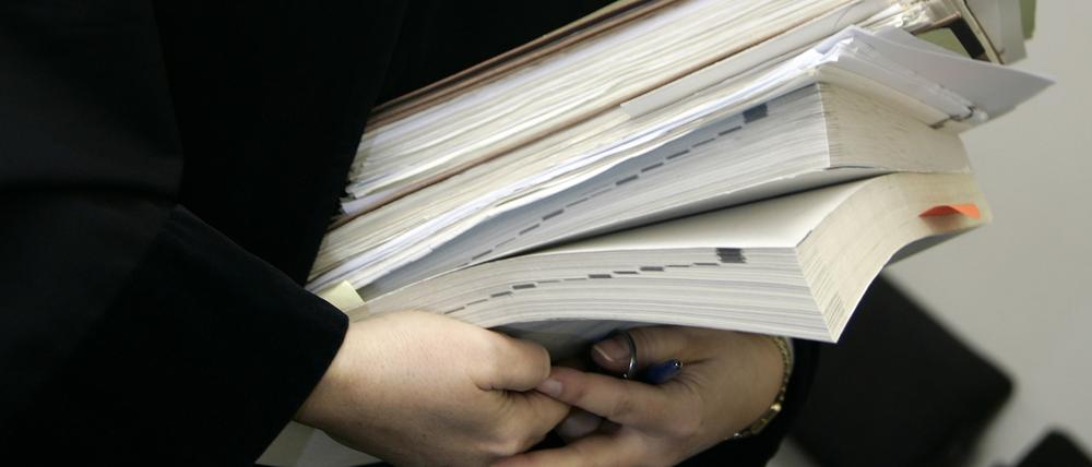 Eine Richterin trägt Bücher und Akten zu einer Verhandlung des Sozialgerichts in der Berliner Invalidenstraße.