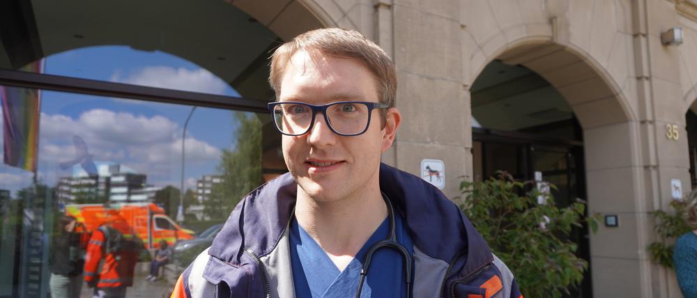 Notarzt Frederick Voß steht in Wuppertal vor dem Krankenhaus, in dem er arbeitet, wenn er keine Notarzteinsätze hat.