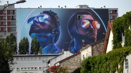 Überlebensgroß. Ademo und N.O.S vom Hip-Hop-Duo PNL auf einer Hochhausfassade in einer französischen Vorstadt.