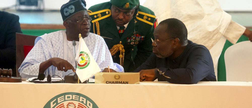 Der Vorsitzende der Wirtschaftsgemeinschaft Westafrikanischer Staaten (Ecowas) und Präsident von Nigeria, Bola Ahmed Tinubu (L), unterhält sich mit dem Präsidenten der Ecowas-Kommission, Omar Touray (R), während der außerordentlichen Sitzung der Ecowas-Staats- und Regierungschefs in Abuja am 10. August 2023. 