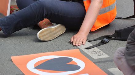 Aktivisten der «Letzten Generation» blockieren eine Straße, auf der sie sich festgeklebt haben.
