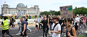 A Participant walks with a sign reading "THC instead of AfD" in front of the Reichstag building during the annual Hemp Parade (Hanfparade), a demonstration for the legalization of hemp, in Berlin's on August 12, 2023. (Photo by Tobias SCHWARZ / AFP)