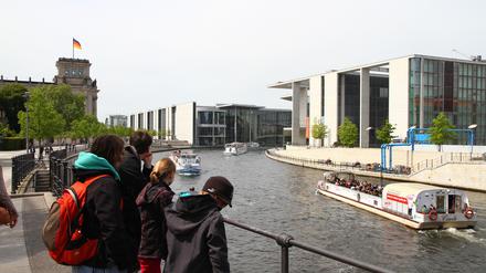 Architektur und Ödnis im zentralen Regierungs- und Parlamentsviertel in Berlin-Mitte: Spaziergänger bummeln an den Spreeufern vor Reichstag, Paul-Löbe-Haus und dem Lüders-Haus (re.).