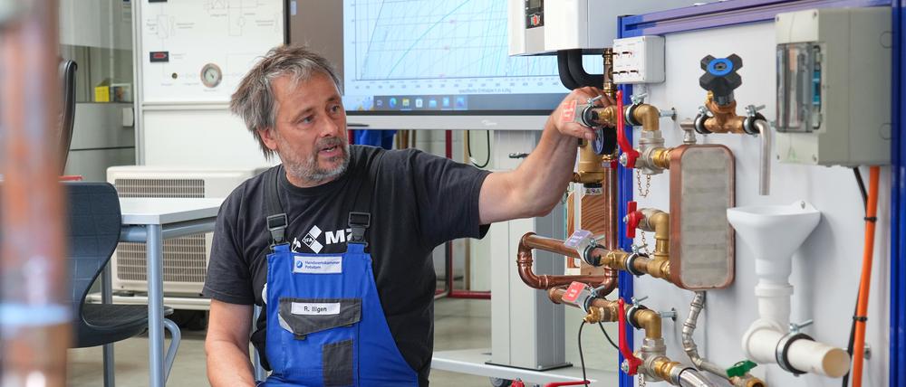 Ein Ausbilder erläutert den Aufbau einer Wärmepumpe.