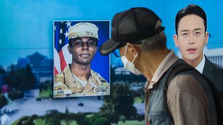 In this photo taken in Seoul on August 16, 2023, a man walks past a television showing a news broadcast featuring a photo of US soldier Travis King (C), who ran across the border into North Korea while part of a tour group visiting the Demilitarized Zone on South Korea's border on July 18. Travis King defected to North Korea to escape "mistreatment and racial discrimination in the US Army", state media said Wednesday, Pyongyang's first official confirmation they were holding the American soldier. (Photo by Anthony WALLACE / AFP)