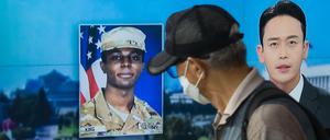In this photo taken in Seoul on August 16, 2023, a man walks past a television showing a news broadcast featuring a photo of US soldier Travis King (C), who ran across the border into North Korea while part of a tour group visiting the Demilitarized Zone on South Korea's border on July 18. Travis King defected to North Korea to escape "mistreatment and racial discrimination in the US Army", state media said Wednesday, Pyongyang's first official confirmation they were holding the American soldier. (Photo by Anthony WALLACE / AFP)