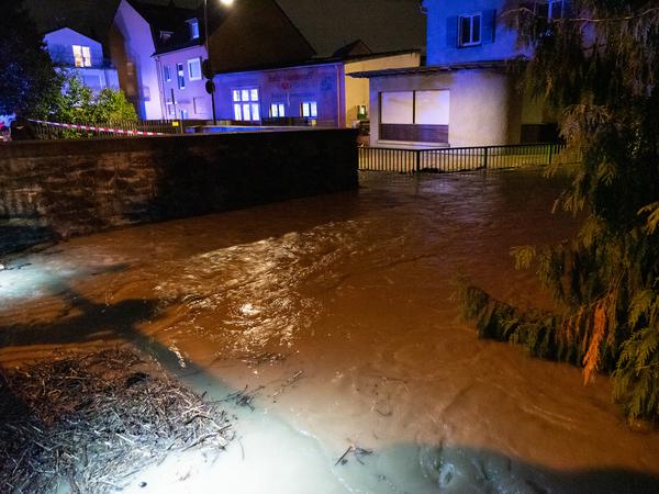 16.08.2023, Frankfurt/Main: Nach starken Regenfällen läuft dreckiges Wasser über eine Straße in Frankfurt-Sossenheim.