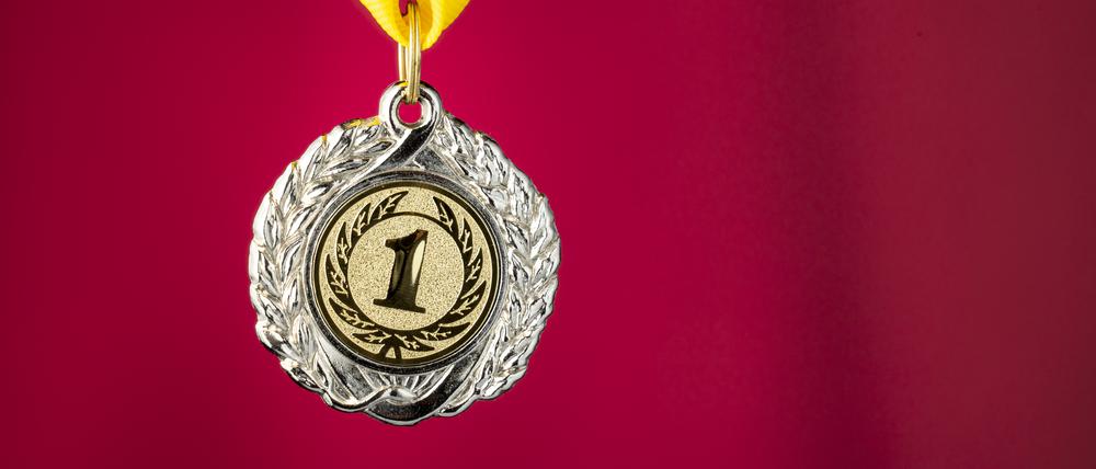 medal for first place in the sports competition close-up on a red background, The prize for winning, studio photo