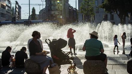 Münchner genießen am 10. August 2023 die Abendsonne am Stachusbrunnen.