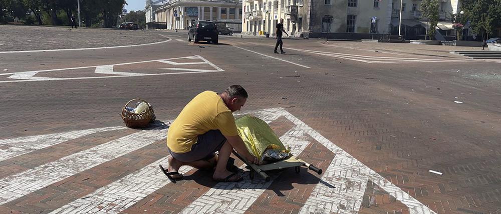 Auf diesem von der Nationalen Polizei der Ukraine via AP zur Verfügung gestellten Foto bedeckt ein Mann eine Leiche nach einem russischen Angriff in Tschernihiw.