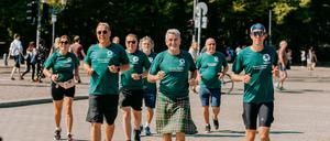Die Läufer um John McGurk (M.) des „Friedenslaufes“ kommen am Brandenburger Tor an. 