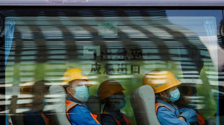 Arbeiter verlassen eine Baustelle im Finanzdistrikt von Peking am Ende ihrer Schicht. Die Abkühlung des Bausektors verlangsamt das Wirtschaftswachstum in China.
