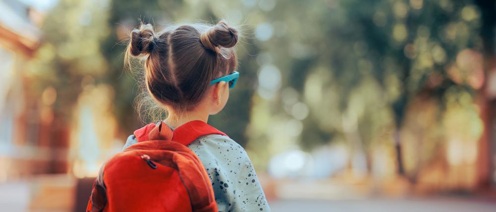 Child wearing a backpack ready for the first day of kindergarten