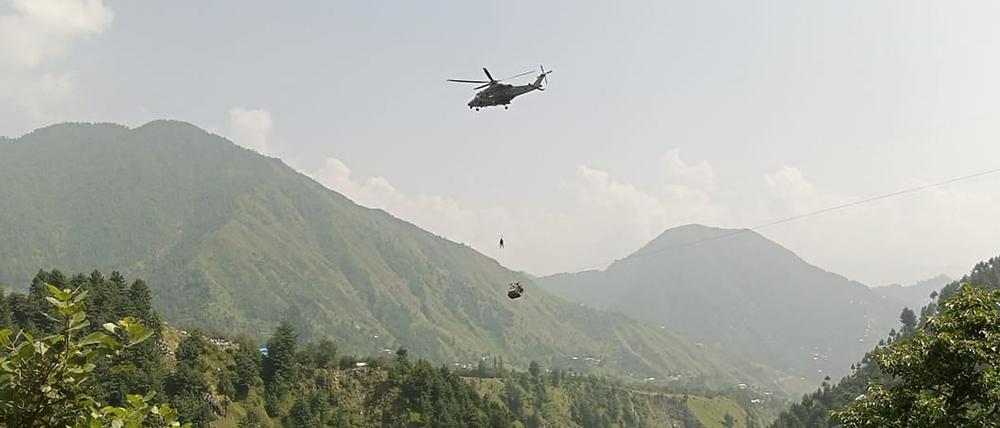 Ein Armeesoldat seilt sich von einem Hubschrauber ab, um Schüler zu bergen, die in einem Sessellift festsitzen.