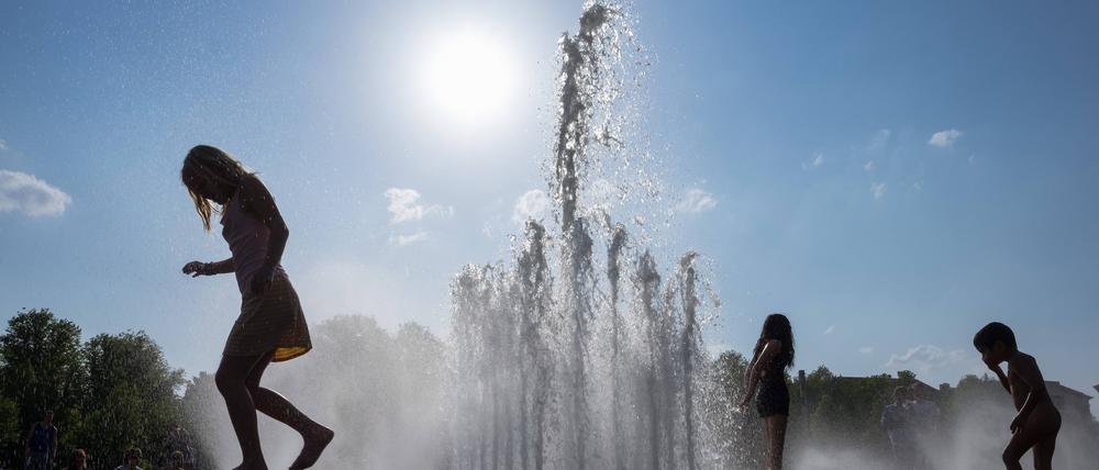 Kinder spielen am Brunnen im Lustgarten auf der Museumsinsel in Berlin-Mitte.