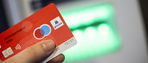 Eine Bankkundin verwendet ihre Girokarte, um Bargeld an einem Geldautomaten abzuheben.