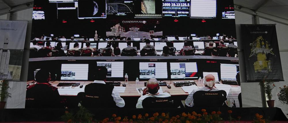 23.08.2023, Indien, Bengaluru: Wissenschaftler der Indischen Weltraumforschungsorganisation (ISRO) werden auf einen Bildschirm projiziert und warten auf die Landung des Raumschiffs Chandrayaan-3 auf dem Mond in der ISRO-Einrichtung für Telemetrie, Verfolgung und Kommandonetzwerke. Indien ist als viertem Land eine sanfte Landung auf dem Mond geglückt. Die Mondsonde sei sicher auf dem Erdtrabanten angekommen, teilte die indische Weltraumbehörde ISRO am Mittwoch mit. Foto: Aijaz Rahi/AP/dpa +++ dpa-Bildfunk +++