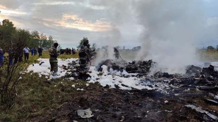 Feuerwehrleute arbeiten inmitten von Flugzeugwrackteilen an einer Unfallstelle nach dem Absturz eines Privatjets in der Region Twer.