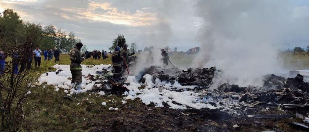 Feuerwehrleute arbeiten inmitten von Flugzeugwrackteilen an einer Unfallstelle nach dem Absturz eines Privatjets in der Region Twer.