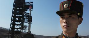 Ein nordkoreanischer Soldat steht vor einer Unha-3 Rakete an einer Abschussrampe an der Westküste Nordkoreas.