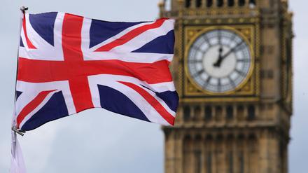 Eine britische Fahne weht vor dem berühmten Uhrturm Big Ben.