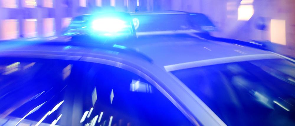 Ein Streifenwagen der Polizei steht mit eingeschaltetem Blaulicht auf der Straße. (Symbolbild)