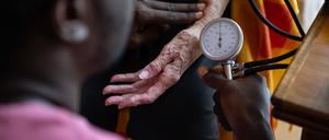 15.08.2023, Baden-Württemberg, Filderstadt: Eine Auszubildender zum Pflegefachmann im Besitz eines Ausbildungsvisums, führt bei einer Bewohnerin der Pflegeeinrichtung ·Wohngemeinschaft für Senioren· eine Blutdruckmessung durch. 