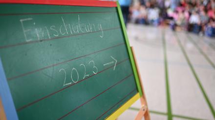 Einschulung 2023· steht an einer Tafel während einer Einschulungsfeier von Erstklässlerinnen und Erstklässlern. 